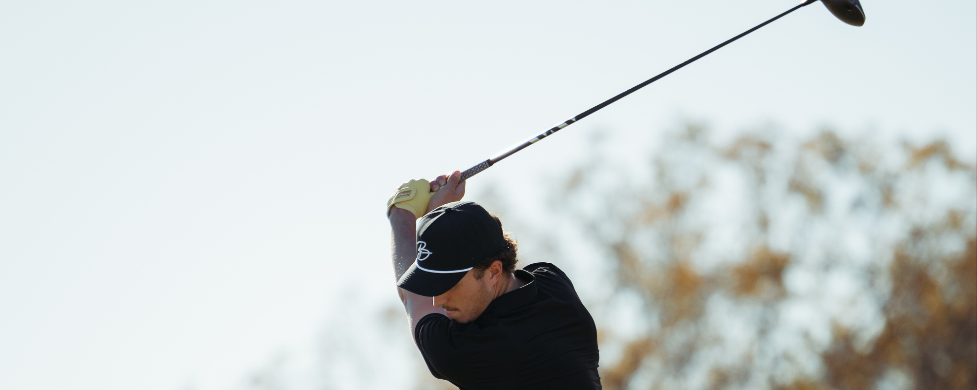 Golfer hitting with a driver.