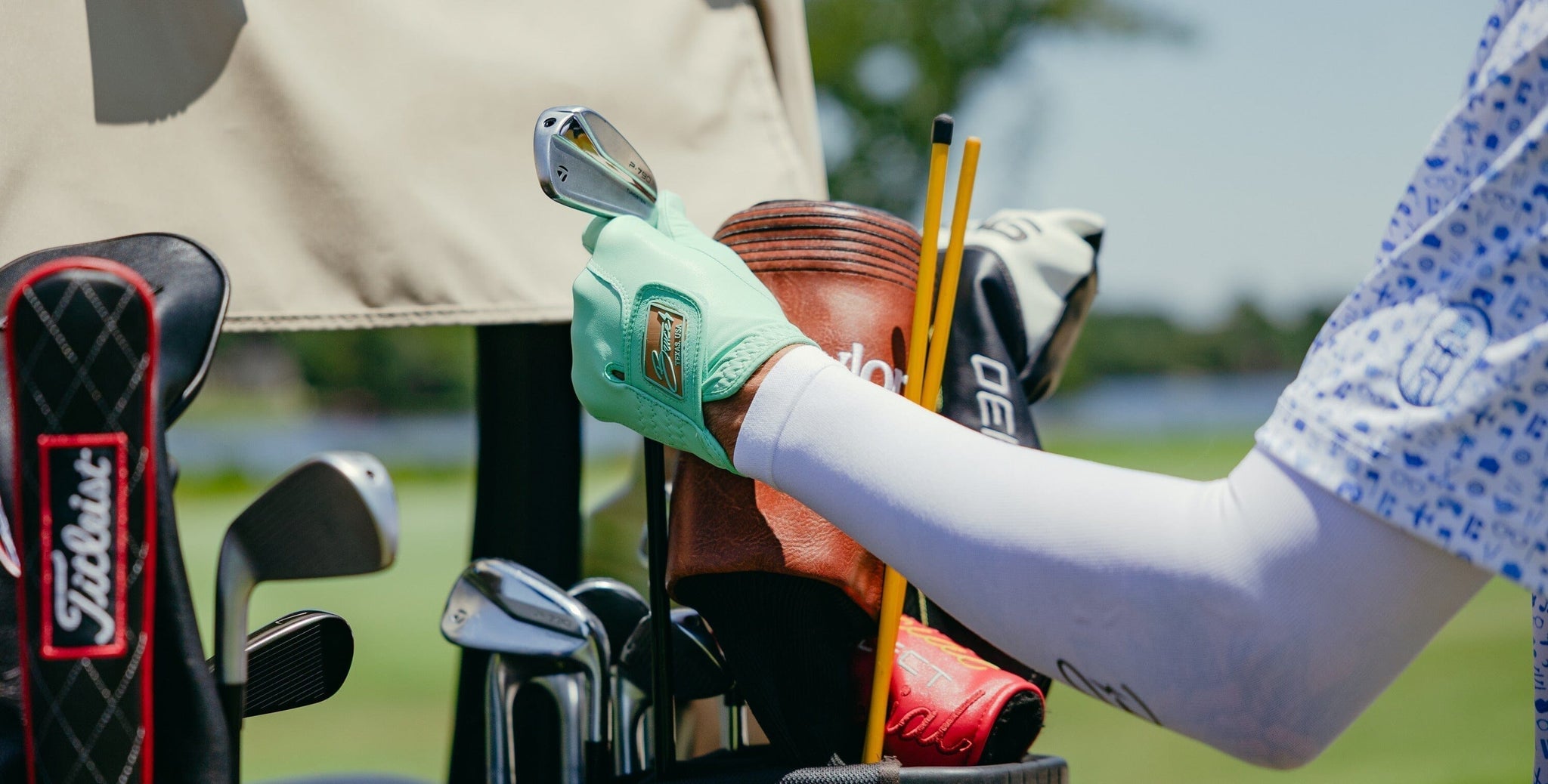Person picking out a golf club.