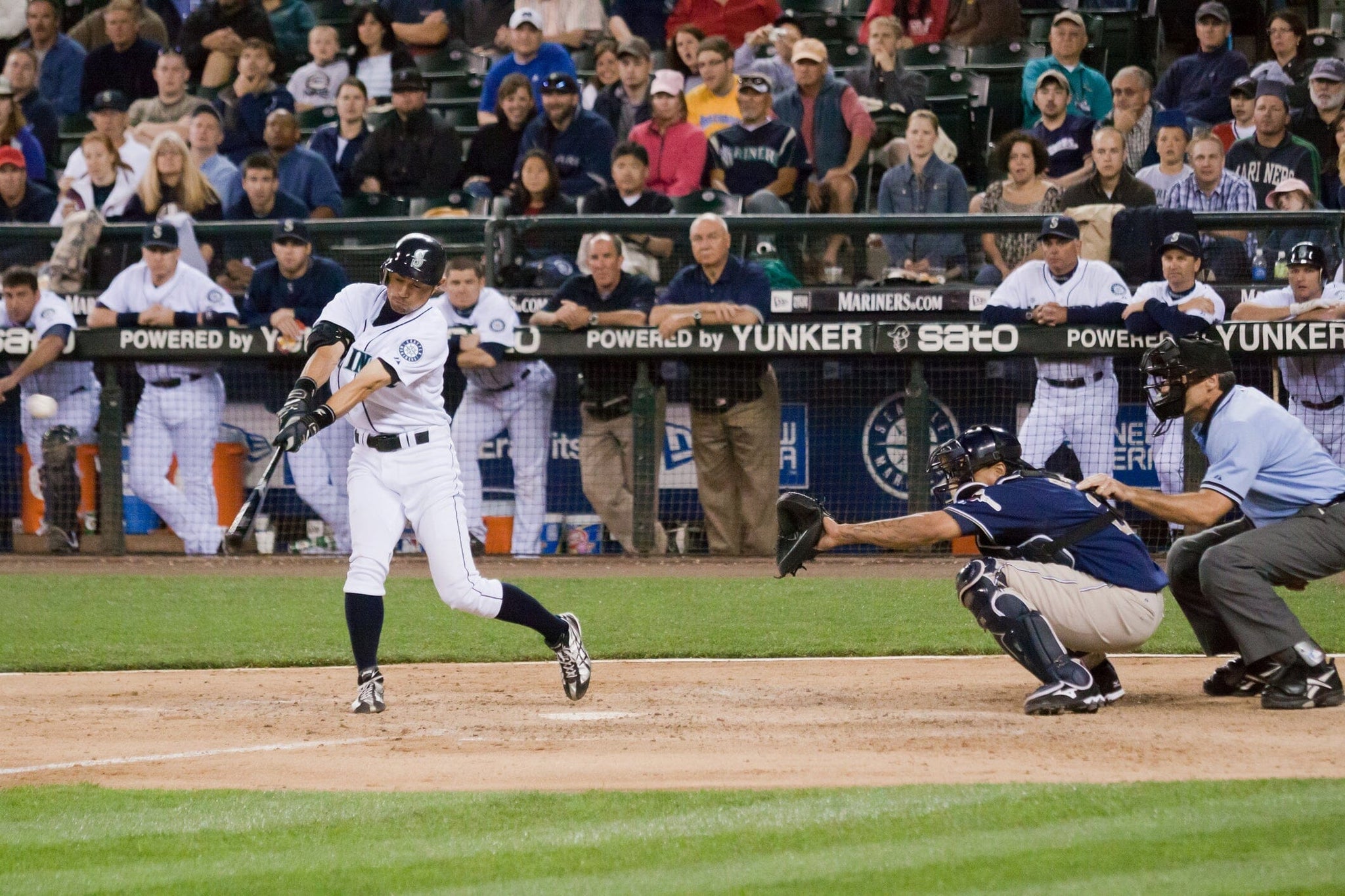 Baseball player swinging at the ball in game.