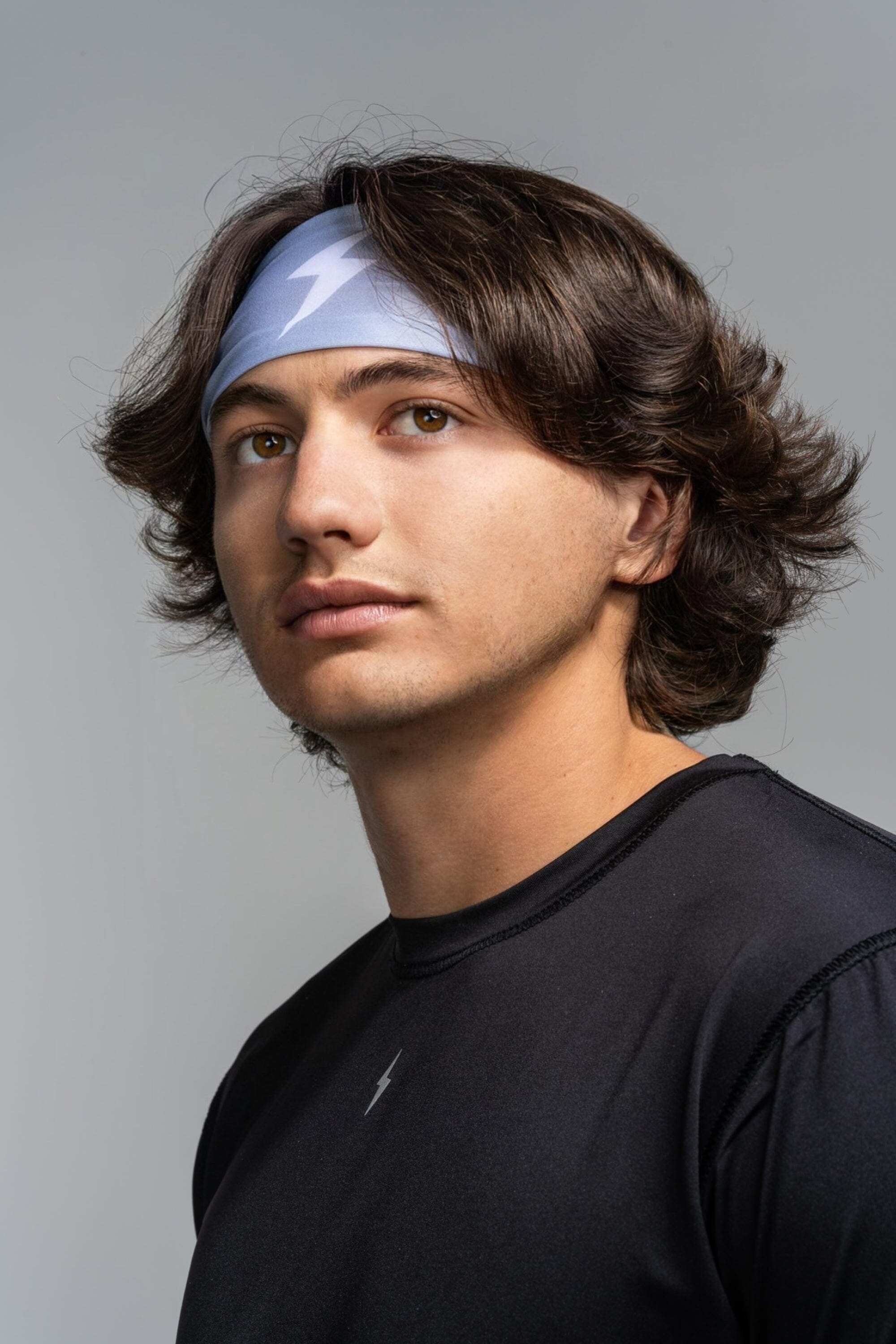 A person wearing a grey performance headband.