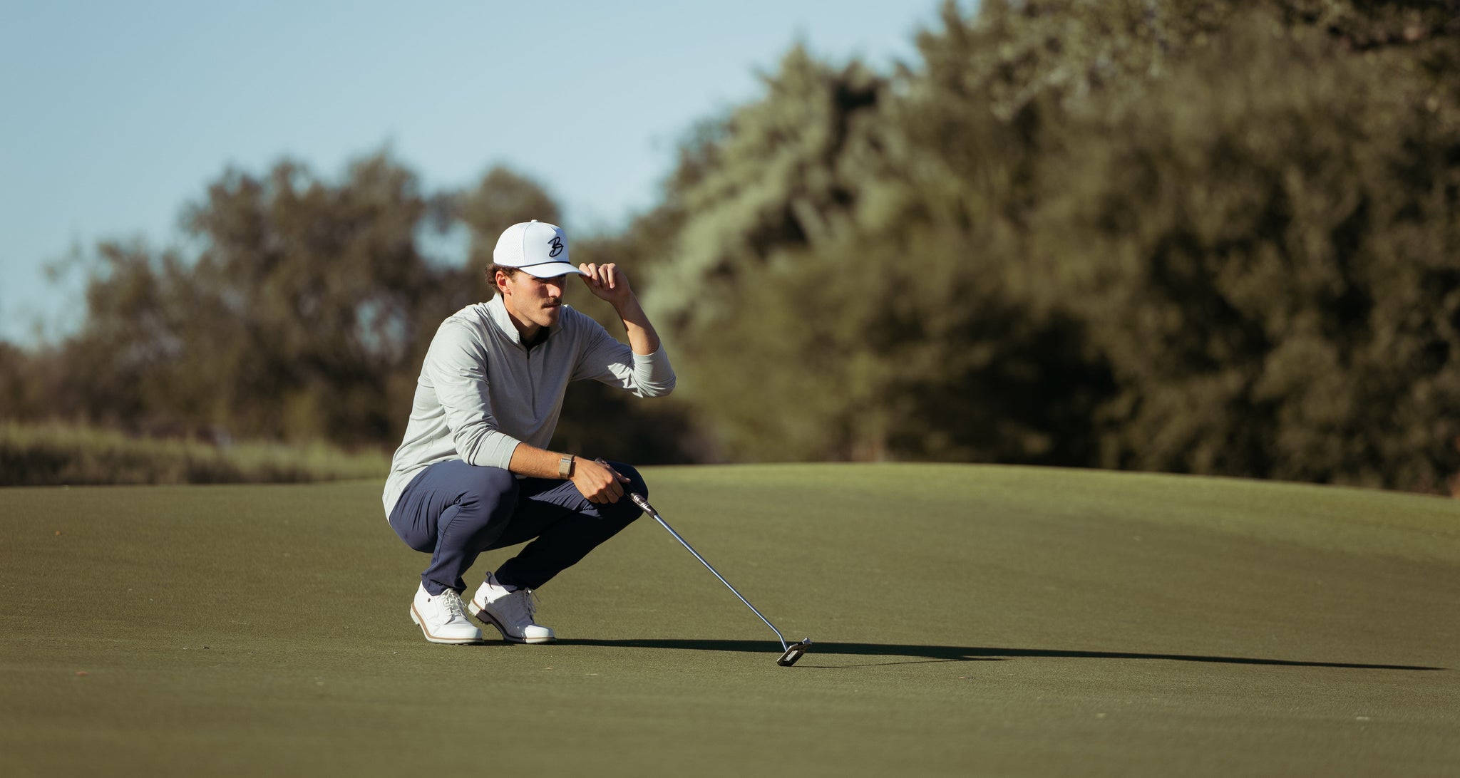 Golfer watching ball on the green.
