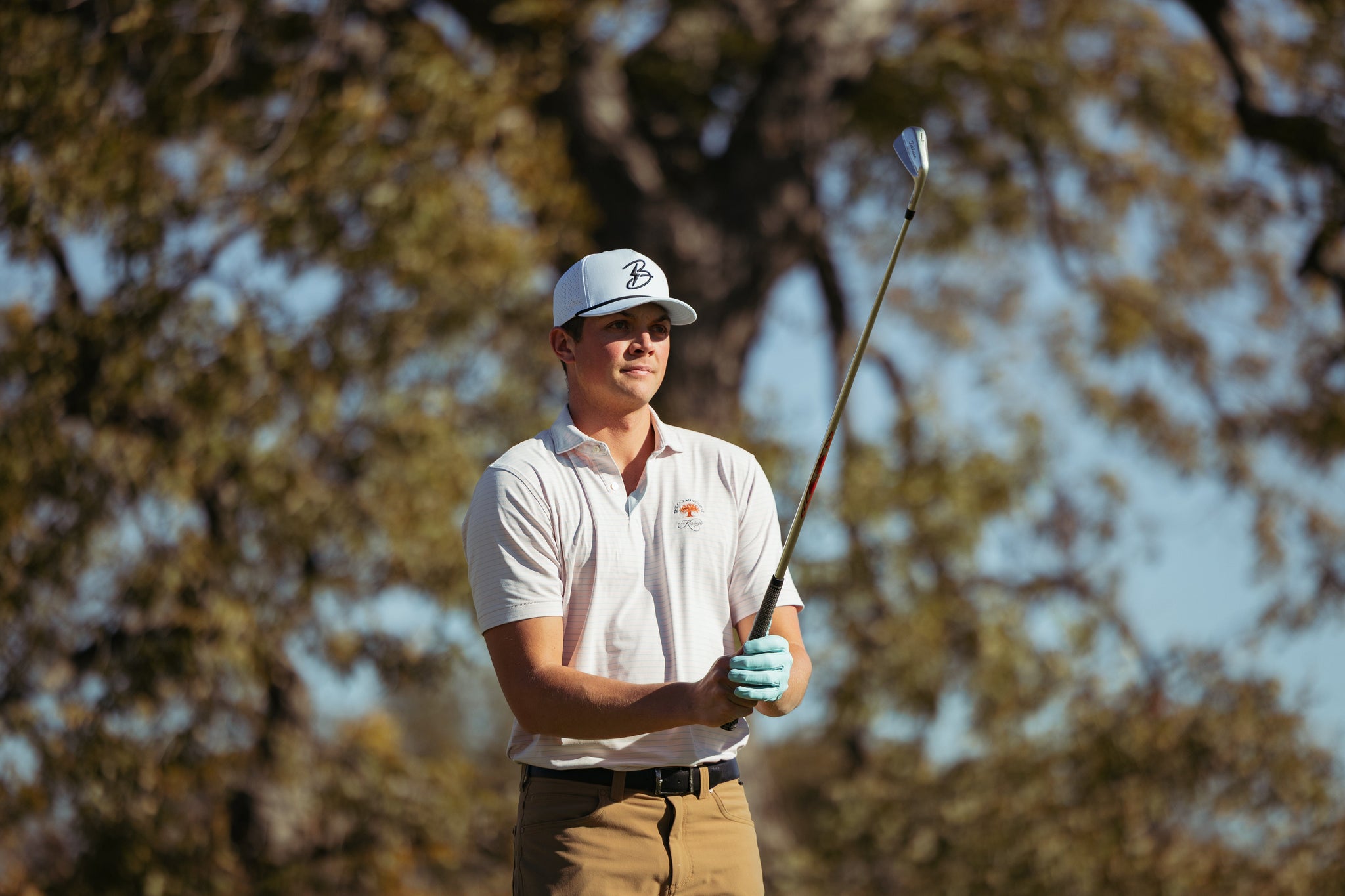 Golfer holding up club. 