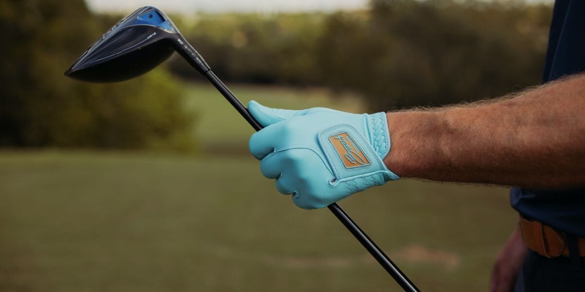 Person holding a golf club.