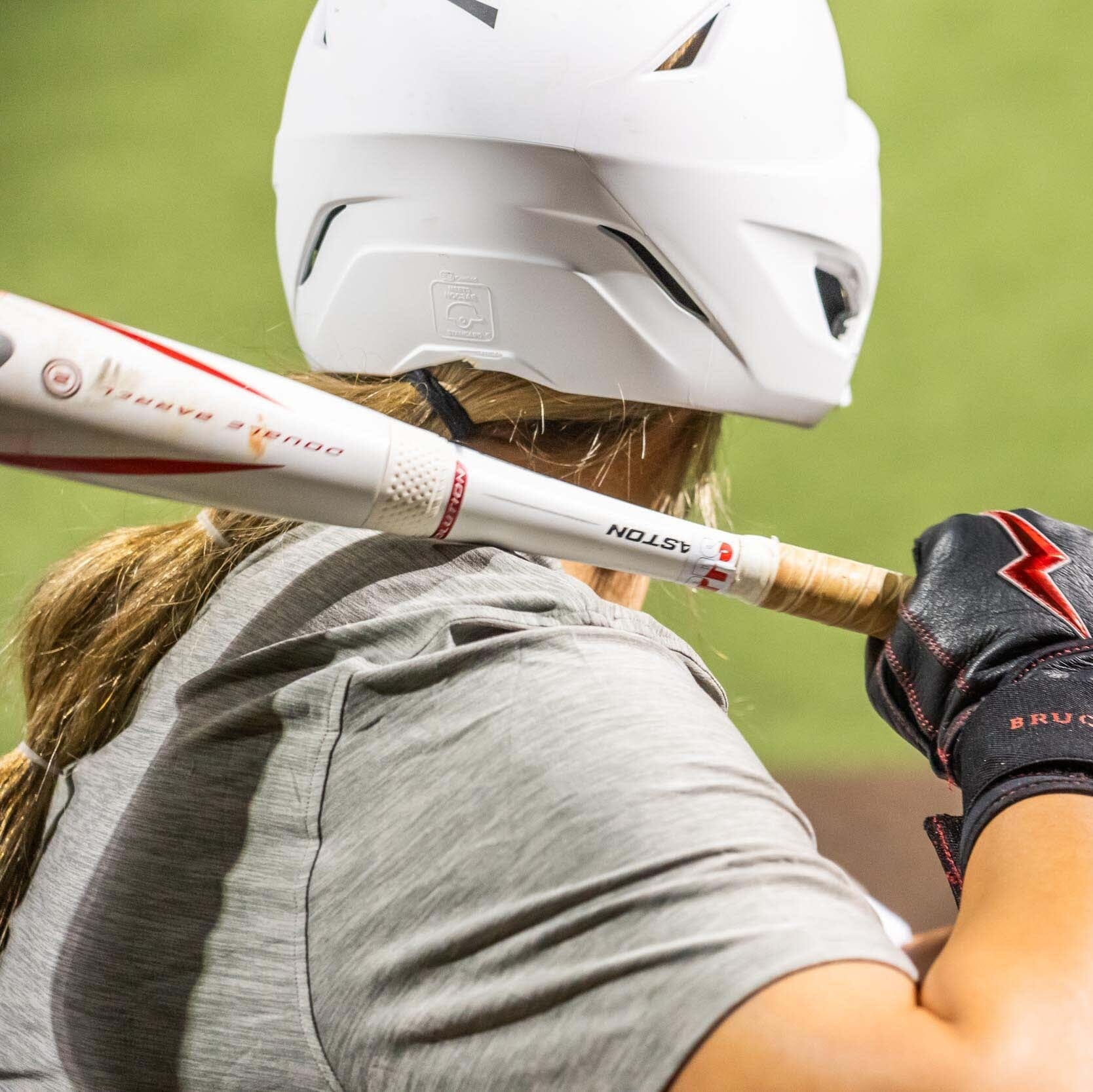Girl holding a softball bat getting ready to swing. 