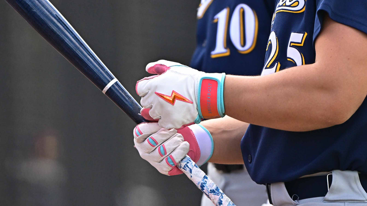 Man holding a baseball bat wearing Bruce Bolt batting gloves